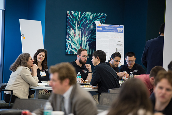 One of the tables at lunch during the expo with about ten people engaged in a discussion.