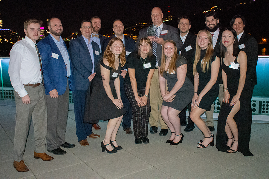 Group shot of twelve students smiling at night