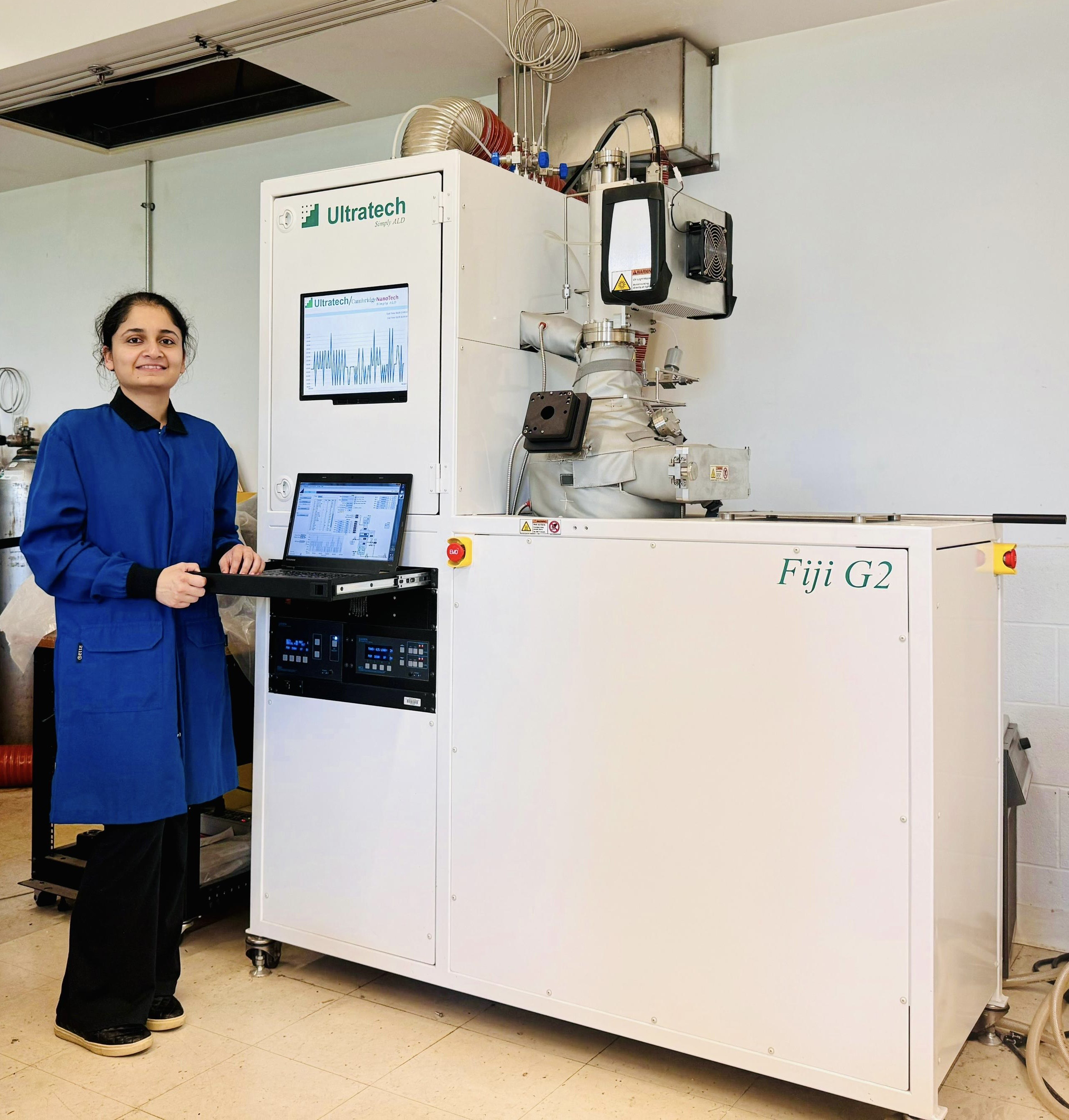 A woman standing next to a 3D printer