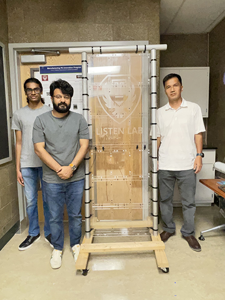 Three men standing with their project