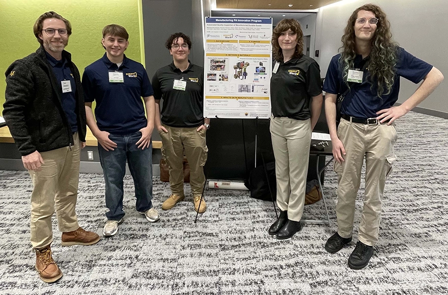 A team of five students in front of their poster